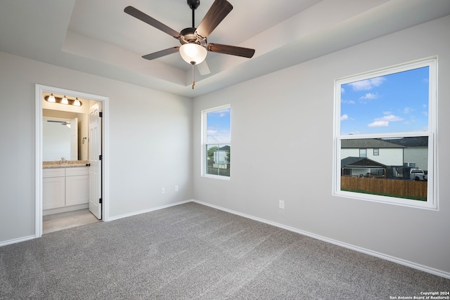 unfurnished bedroom with connected bathroom, ceiling fan, and light colored carpet