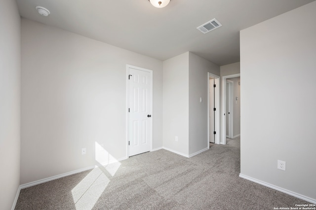 unfurnished bedroom featuring light carpet and a closet