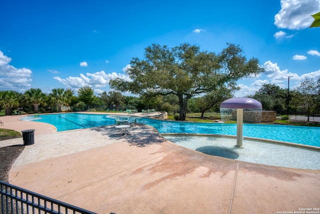 view of pool featuring pool water feature and a patio