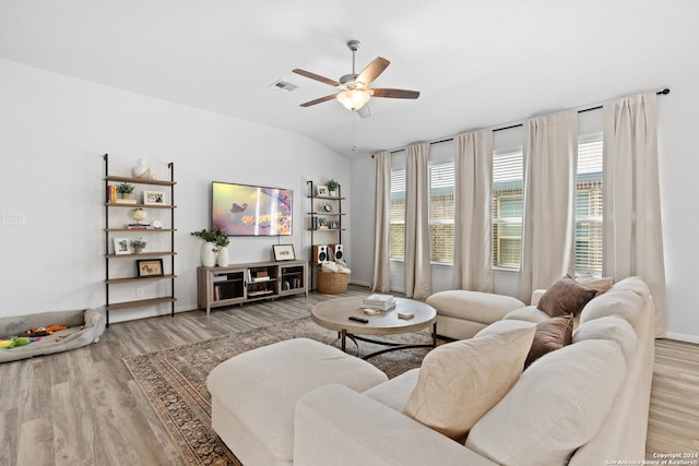 living room with ceiling fan, vaulted ceiling, and hardwood / wood-style floors