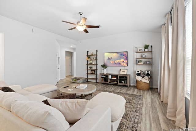 living room featuring light hardwood / wood-style floors, vaulted ceiling, ceiling fan, and a wealth of natural light