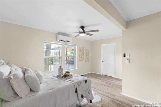 bedroom featuring light wood-type flooring, crown molding, ceiling fan, and a wall unit AC