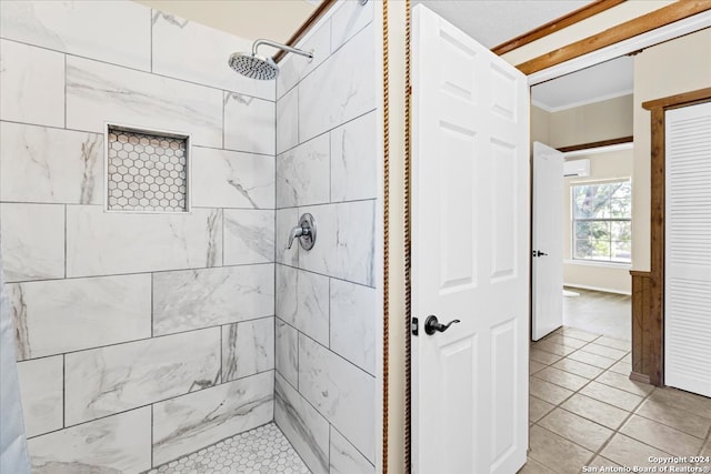 bathroom featuring ornamental molding, tile patterned flooring, a tile shower, and a wall mounted AC