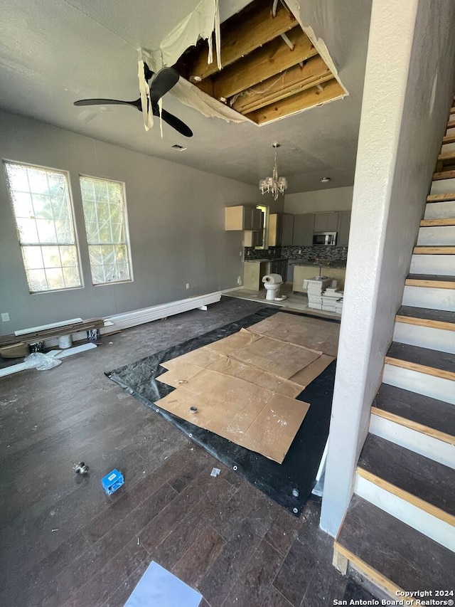 interior space with ceiling fan with notable chandelier