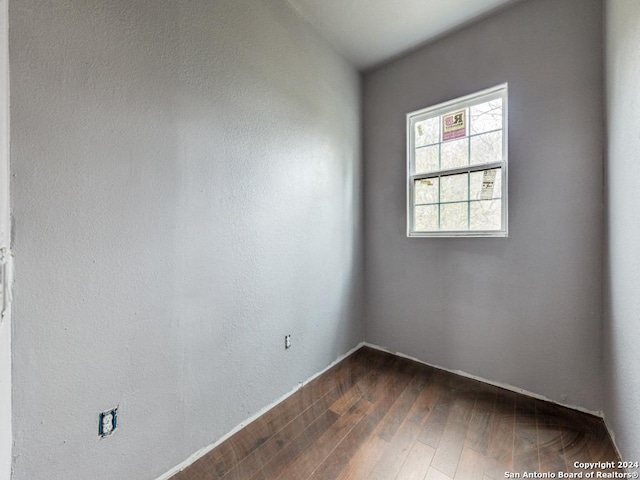 unfurnished room with dark wood-type flooring