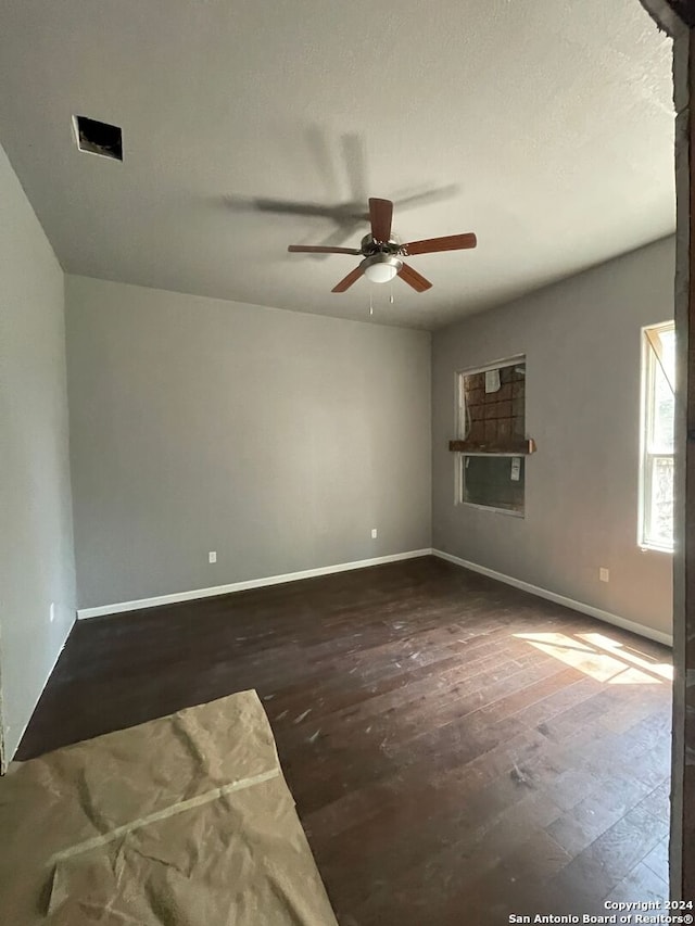 spare room with ceiling fan and dark hardwood / wood-style flooring