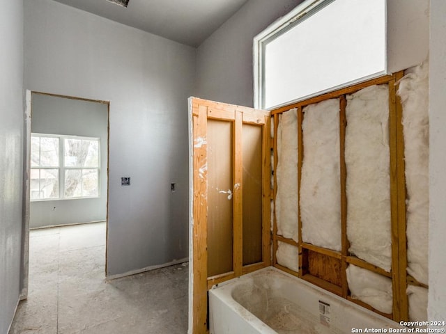 bathroom with a tub to relax in and plenty of natural light