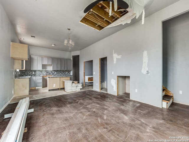 unfurnished living room with stairs and an inviting chandelier