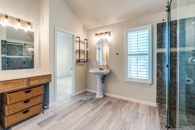 bathroom with lofted ceiling, walk in shower, and hardwood / wood-style floors