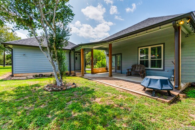 back of property featuring a lawn and a patio area