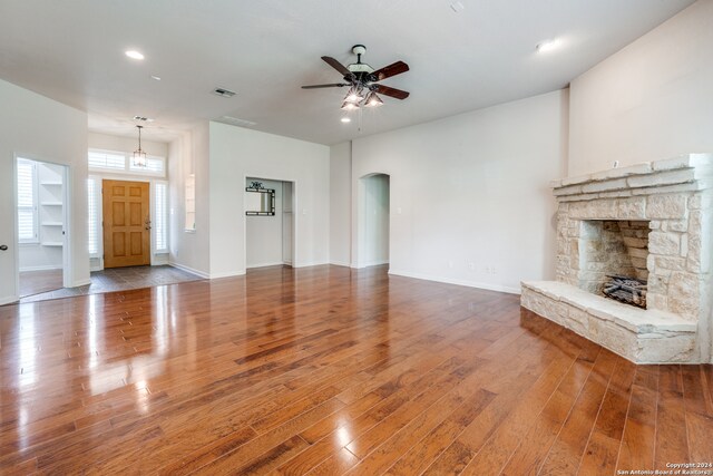 unfurnished living room featuring ceiling fan, a fireplace, and hardwood / wood-style floors