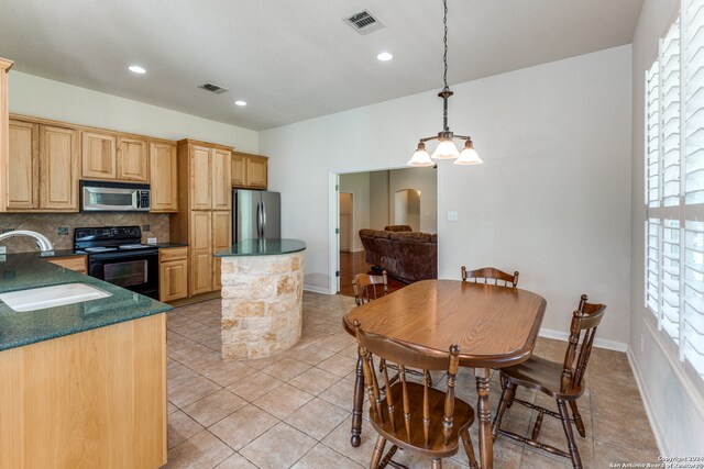 kitchen with stainless steel appliances, hanging light fixtures, a healthy amount of sunlight, and sink