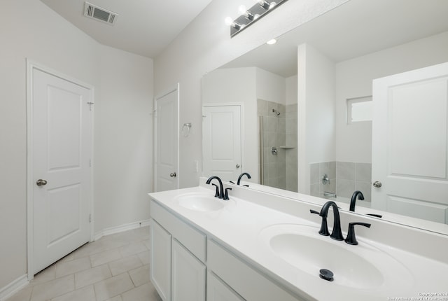 bathroom featuring vanity, a tile shower, and tile patterned floors