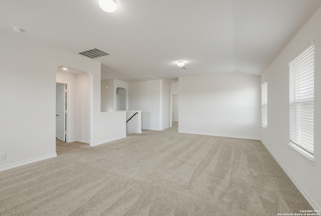 empty room with lofted ceiling and light colored carpet