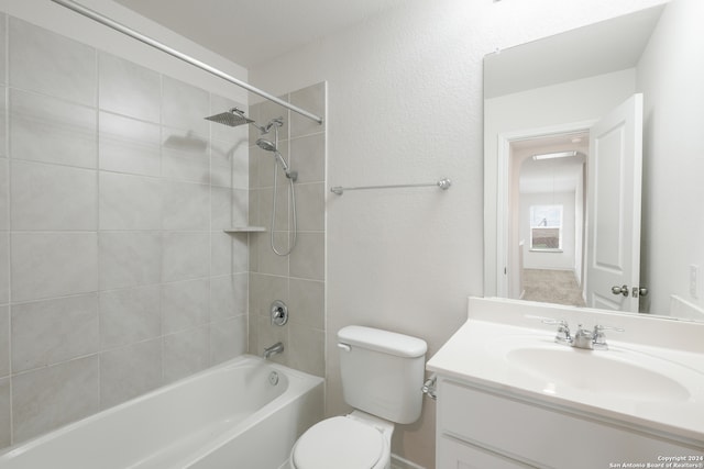 full bathroom with vanity, tiled shower / bath combo, and toilet