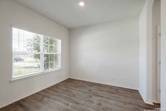 empty room with hardwood / wood-style flooring and plenty of natural light