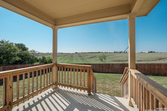 deck with a yard and a rural view