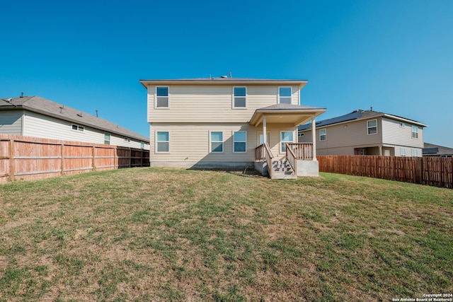 back of property featuring a yard