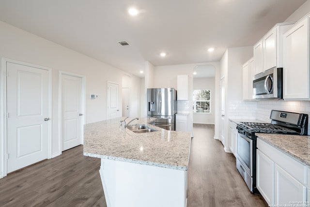 kitchen featuring an island with sink, sink, wood-type flooring, white cabinetry, and appliances with stainless steel finishes