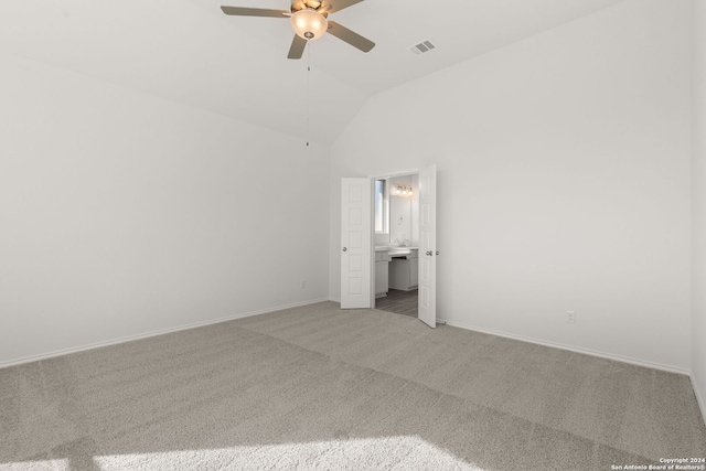 unfurnished bedroom featuring carpet floors, ensuite bathroom, ceiling fan, and vaulted ceiling