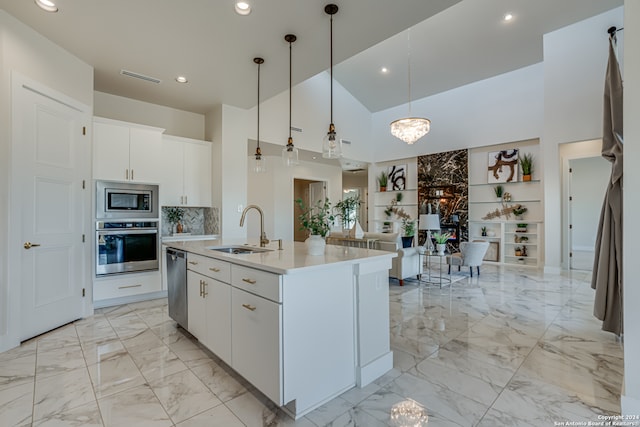 kitchen featuring appliances with stainless steel finishes, white cabinetry, pendant lighting, and sink