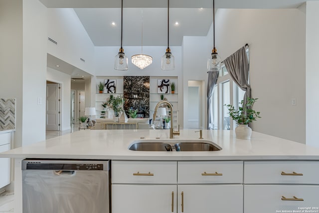 kitchen featuring white cabinets, a kitchen island with sink, sink, pendant lighting, and dishwasher