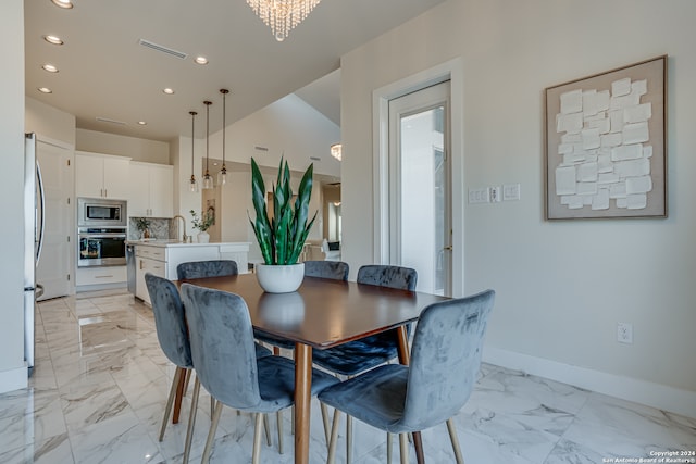 dining area with sink and a chandelier