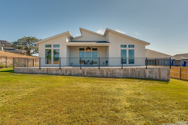 back of house featuring a yard and ceiling fan