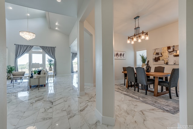 dining area featuring a wealth of natural light, high vaulted ceiling, and a notable chandelier