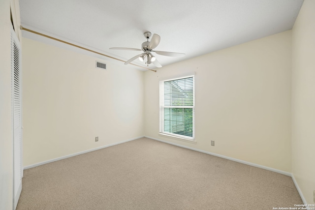 unfurnished bedroom featuring light carpet, a closet, and ceiling fan