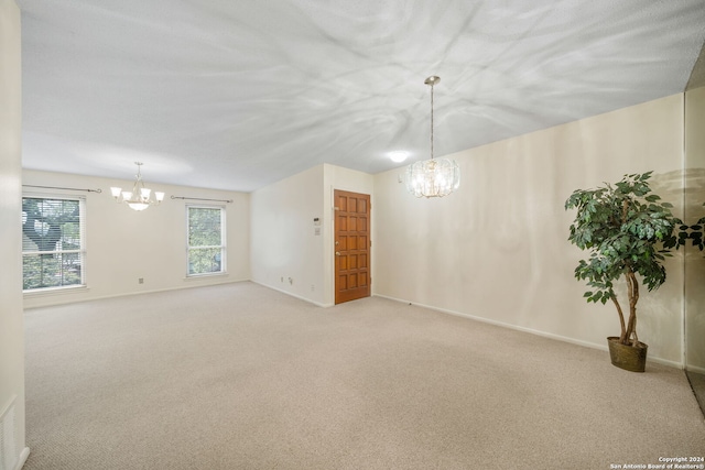 unfurnished room with a chandelier and light carpet