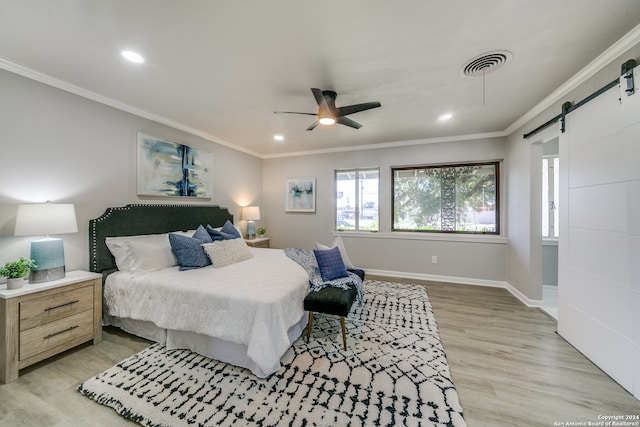 bedroom with a barn door, ornamental molding, light wood-type flooring, and ceiling fan