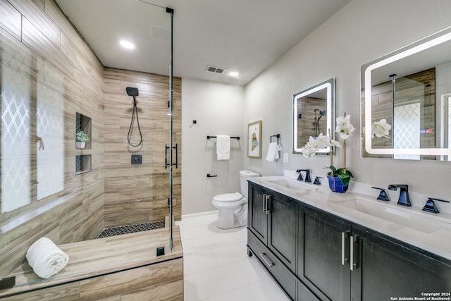 bathroom with tile patterned flooring, vanity, toilet, and a shower with shower door