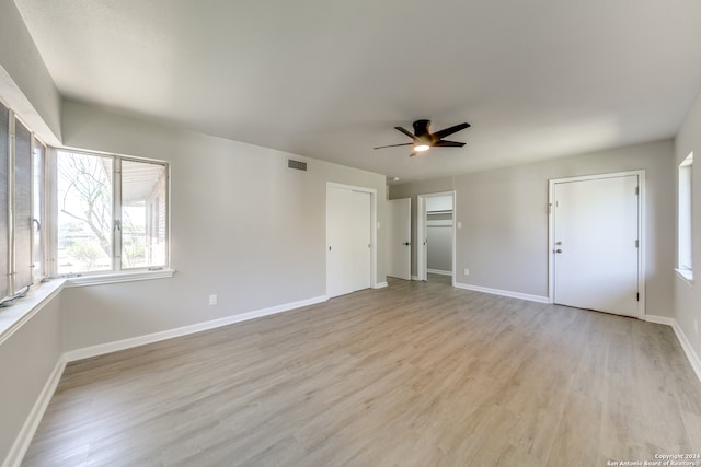 interior space with ceiling fan, multiple closets, and light hardwood / wood-style flooring