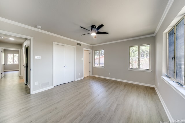 unfurnished bedroom with multiple windows, light hardwood / wood-style floors, ornamental molding, and ceiling fan