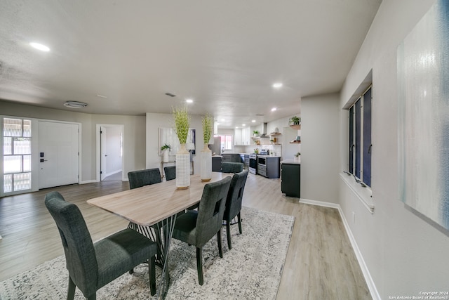 dining space with light wood-type flooring and a healthy amount of sunlight