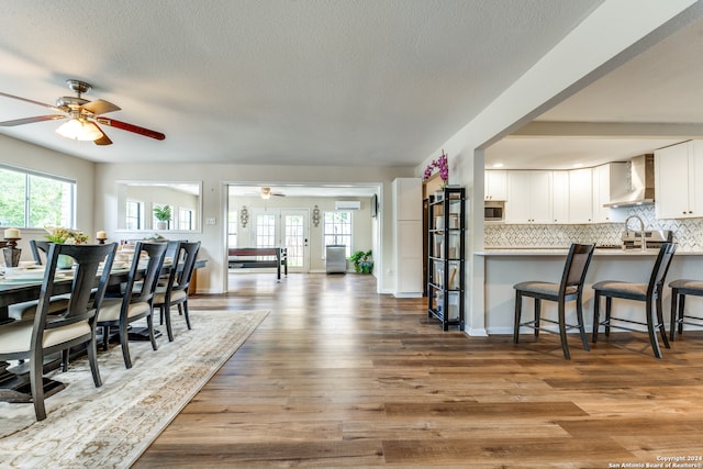 dining room featuring a textured ceiling, french doors, sink, and light hardwood / wood-style flooring