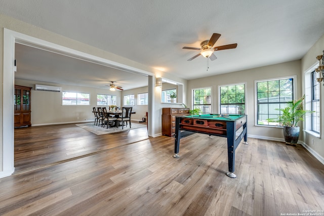 recreation room with a wall mounted air conditioner, ceiling fan, hardwood / wood-style flooring, and billiards