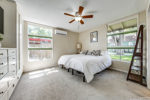 bedroom with light colored carpet, a wall unit AC, and ceiling fan