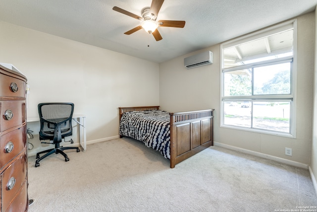 bedroom with ceiling fan, light colored carpet, and a wall mounted AC