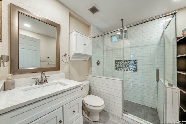 bathroom with vanity, toilet, and an enclosed shower