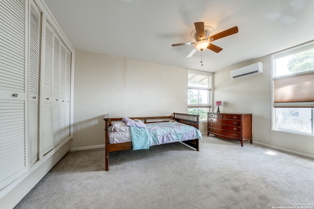 bedroom featuring ceiling fan, an AC wall unit, and light carpet