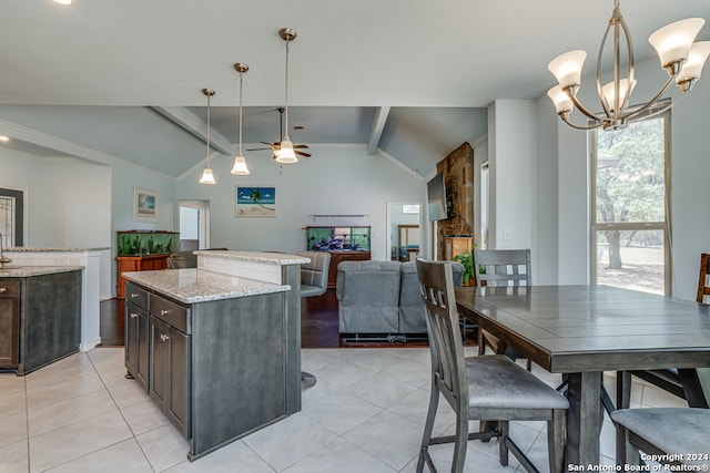 kitchen featuring pendant lighting, vaulted ceiling with beams, a kitchen island, dark brown cabinets, and light stone countertops