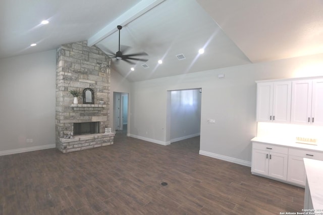 unfurnished living room featuring ceiling fan, vaulted ceiling with beams, a fireplace, and dark hardwood / wood-style flooring