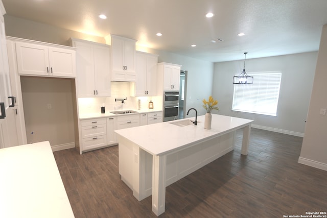 kitchen featuring white cabinetry, dark hardwood / wood-style flooring, decorative light fixtures, black electric stovetop, and sink