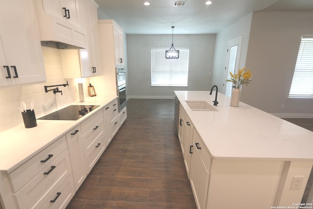 kitchen with light stone counters, sink, white cabinetry, appliances with stainless steel finishes, and dark hardwood / wood-style flooring