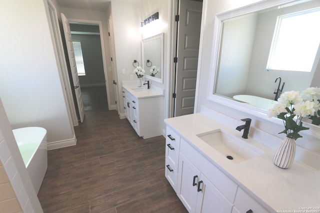 bathroom with wood-type flooring, vanity, and a bathing tub