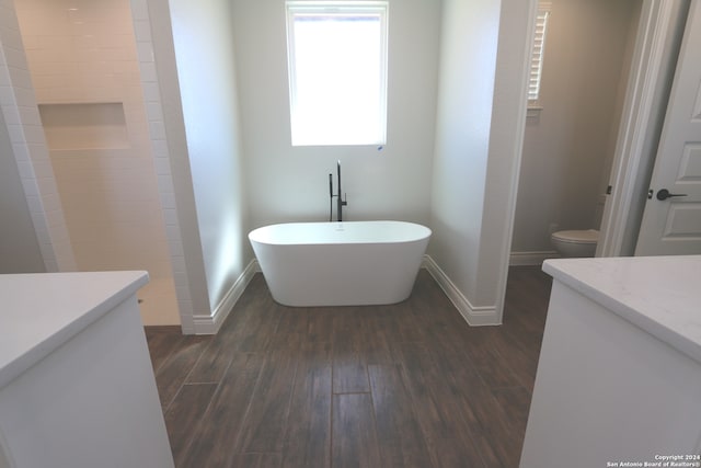 bathroom with vanity, hardwood / wood-style flooring, a bathtub, and toilet