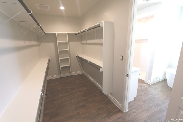 spacious closet with dark hardwood / wood-style flooring