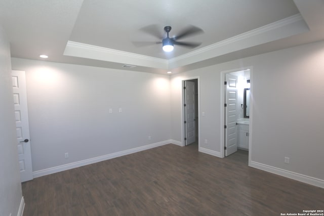 unfurnished bedroom featuring ceiling fan, a raised ceiling, connected bathroom, and dark hardwood / wood-style flooring